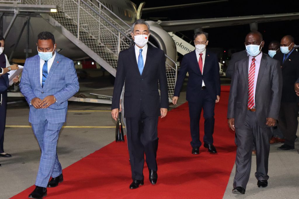 Menteri Luar Negeri Kepulauan Solomon Jeremiah Manale (kiri) dan Kepala Protokol Walter Diamana (kanan) mengiringi Menteri Luar Negeri China Wang Yi (tengah) saat tiba di Bandara Internasional Hendersen di Honiara, 25 Mei 2022.