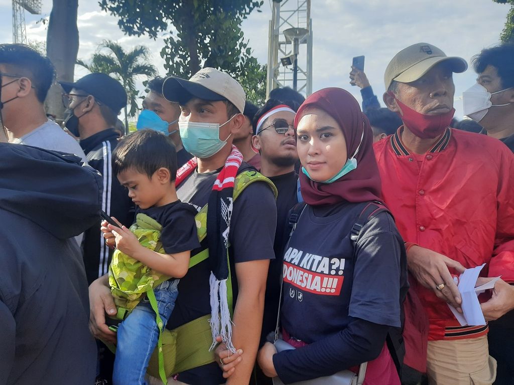 Suporter sepak bola, Resa Audina (25), bersama suami dan anaknya yang berusia 3,5 tahun hadir di depan Stadion Utama Gelora Bung Karno, Jakarta, Jumat (6/1/2023). Demi menonton laga pertama semifinal Piala AFF 2022 antara Indonesia dan Vietnam, mereka berkendara dengan sepeda motor dari Depok, Jawa Barat.
