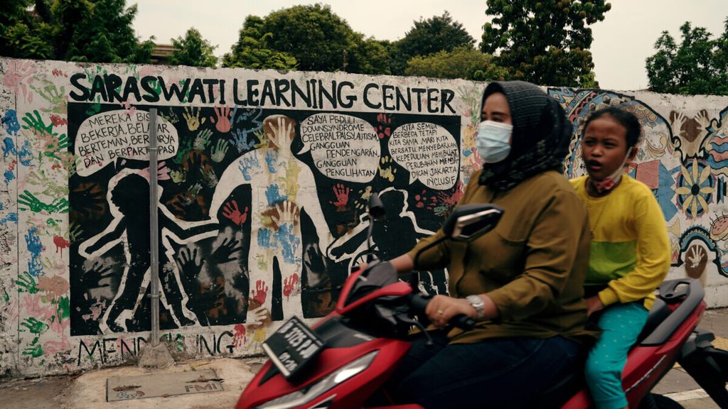 Warga melintasi mural peduli sesama di Cempaka Putih, Jakarta Pusat, Kamis (7/10/2021). Ajakan peduli sesama terus disuarakan untuk membuat perubahan yang pada akhirnya bisa bekerja, belajar, dan berkarya bersama-sama untuk kemajuan.