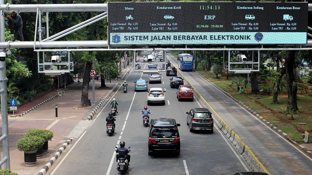 Pekerja tengah menyiapkan penggunaan gerbang jalan berbayar di Jalan Medan Merdeka Barat, Jakarta, Selasa (13/11/2018). 