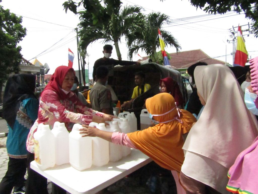 Masyarakat mengantre untuk membeli minyak goreng curah seharga Rp 14.000 per liter dalam kegiatan pasar murah yang digelar Dinas Perindustrian dan Perdagangan Lampung, Jumat (8/4/2022).