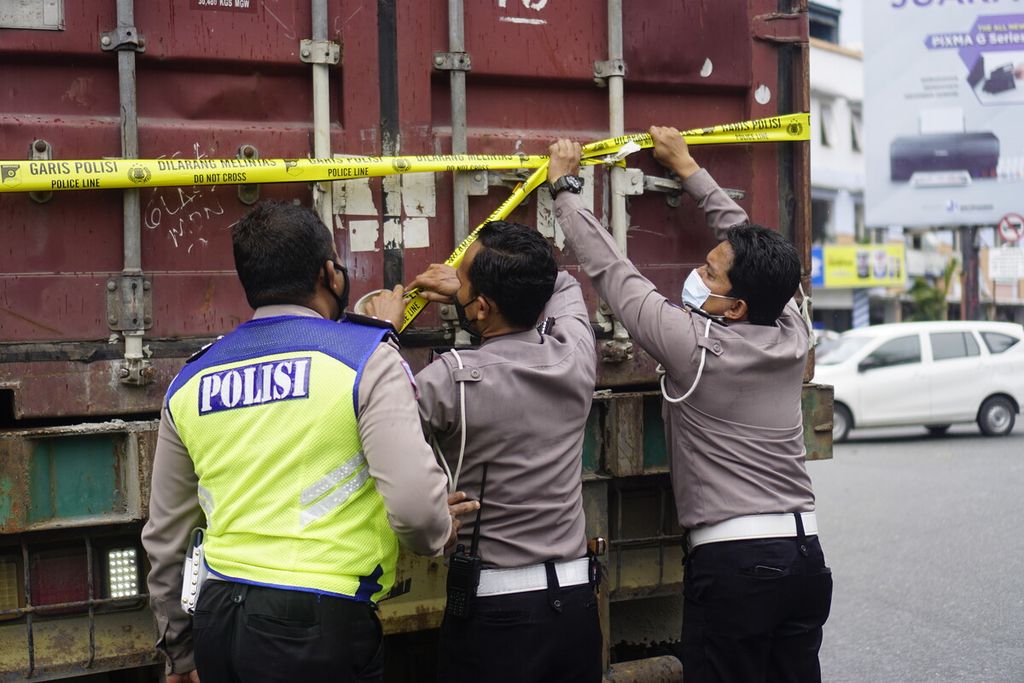 Polisi memasang garis polisi pada truk kontainer yang menabrak belasan kendaraan dalam kecelakaan di Simpang Muara Rapak, Kecamatan Balikpapan Utara, Kota Balikpapan, Kalimantan Timur, Jumat (21/1/2022). Sebanyak 4 korban meninggal dunia, 4 orang luka parah, dan 26 orang luka ringan.