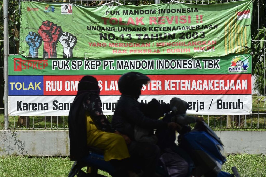 Spanduk penolakan kaum buruh terhadap RUU Ombibus Law Cipta Lapangan Kerja menghiasi Jalan Irian, Jatiwangi, Cikarang Barat, Bekasi, Jawa Barat, Senin (25/5/2020). Pekan lalu, sekalipun DPR sedang reses, Panitia Kerja RUU Cipta Kerja DPR melanjutkan pembahasan RUU Cipta Kerja dengan perwakilan pemerintah. 