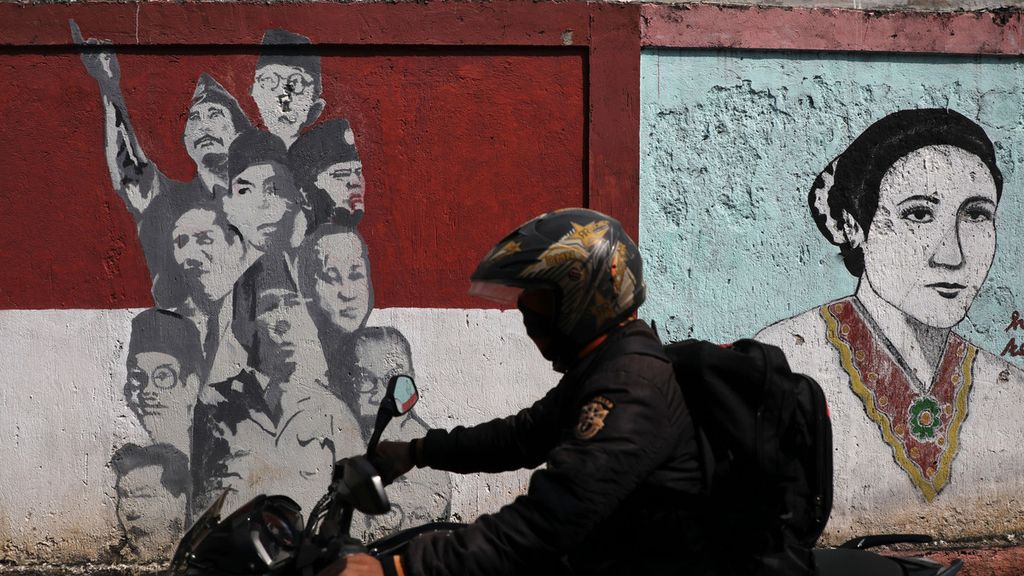 A rider crossing the murals of heroes and presidents decorate the walls at Lengkong Wetan, Serpong, South Tangerang, Banten, Saturday (16/5/2020). The mural is a kind of reminder and motivator for the community in living the life of the nation.