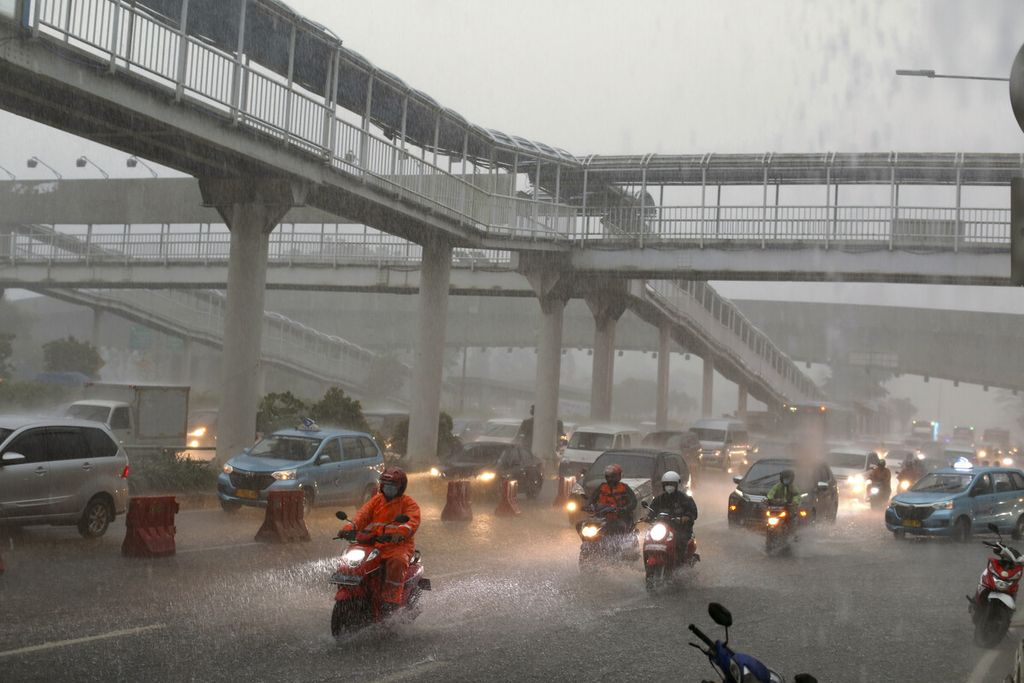 Pengguna kendaraan menembus hujan deras di Jalan Gatot Subroto,  Jakarta Selatan, Jumat (26/11/2021).