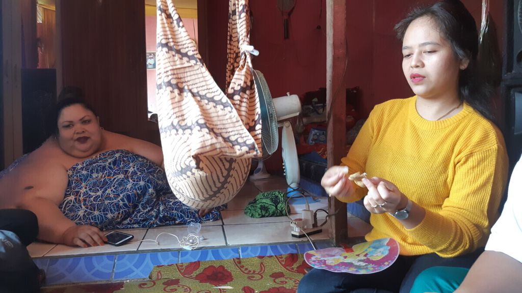 Herlina (19) berbaju kuning bersama ibunya Titi Wati (37), penderita obesitas di Palangkaraya sebelum dibawa ke rumah sakit. Pada Senin, 30 Januari 2023, Titi Wati idikabarkan meninggal setelah sempat dirawat selama satu hari di rumah sakit.