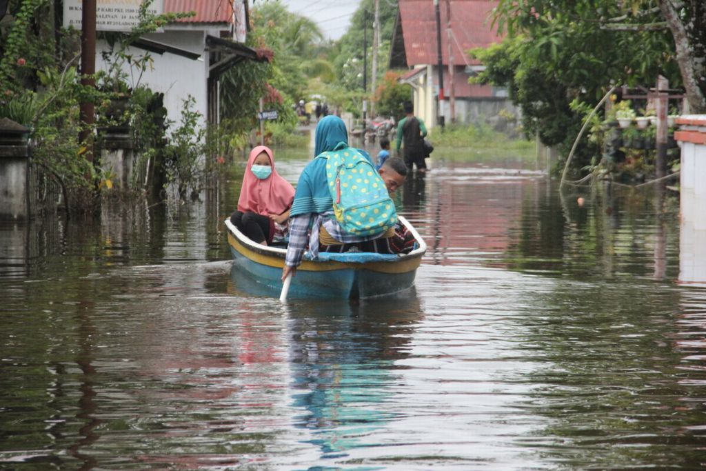 Warga Kecamatan Sintang, Kabupaten Sintang, Kalimantan Barat, mengarungi banjir menggunakan perahu, Sabtu (30/10/2021). Ketinggian banjir di daerah tersebut berkisar 50 sentimeter-1 meter. 
