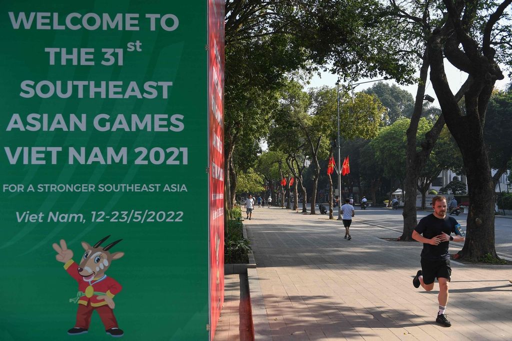 Seorang pelari melewati poster SEA Games Vietnam 2021 di Hanoi, Vietnam, Rabu (4/5/2022). Pesta olahraga terbesar di Asia Tenggara itu akan digelar mulai 12 hingga 23 Mei 2022. 