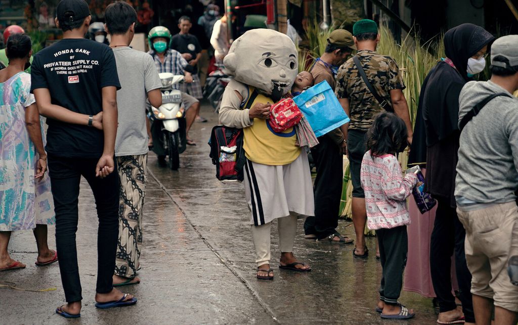 Badut jalanan membawa anak meminta belas kasihan warga di Pasar Jatinegara, Jakarta Timur, Minggu (9/5/2021). Pandemi Covid-19 yang berkepanjangan berdampak besar bagi perekonomian masyarakat yang kian terpuruk. Masyarakat kelas bawah, terutama yang mengandalkan penghasilan harian, melakukan berbagai cara agar bertahan hidup. 