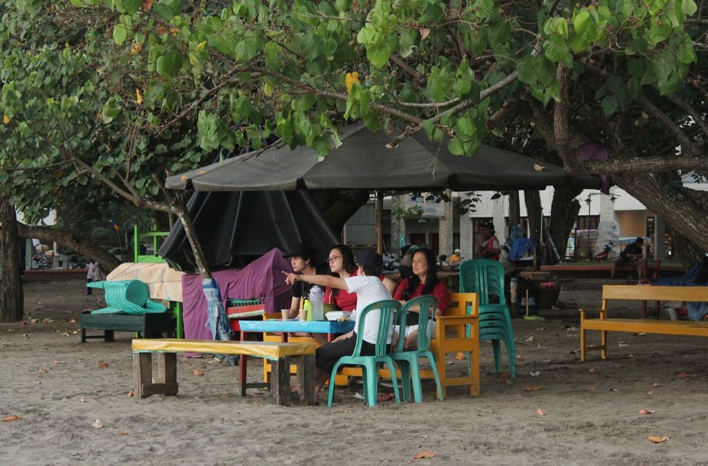 Wisatawan duduk santai di pantai barat Pangandaran, Jawa Barat, Senin (8/8/2022). 