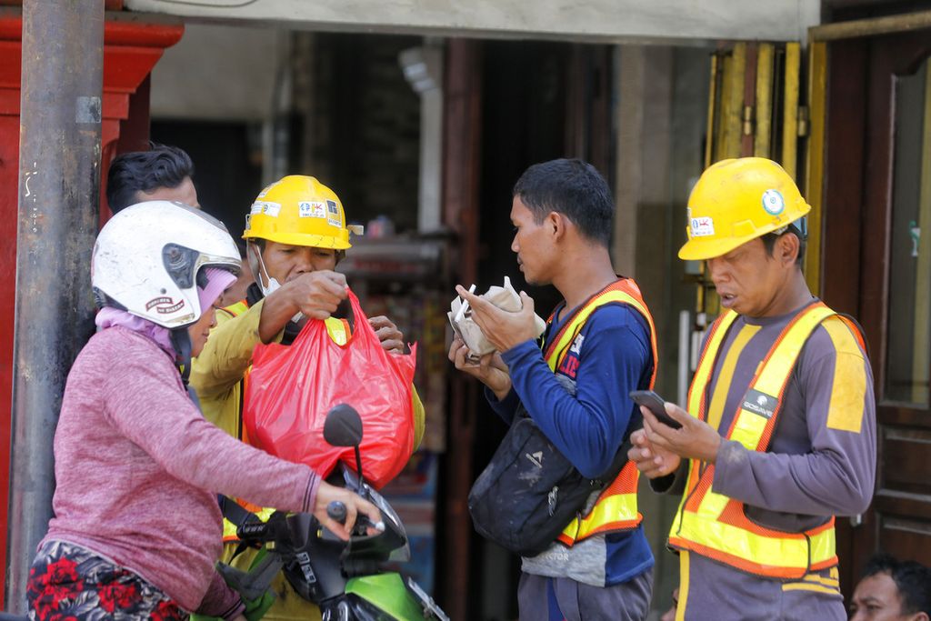 Pekerja pembangunan jalur MRT sedang memesan makanan saat istirahat siang di kawasan Glodok, Jakarta, Minggu (20/11/2022). 