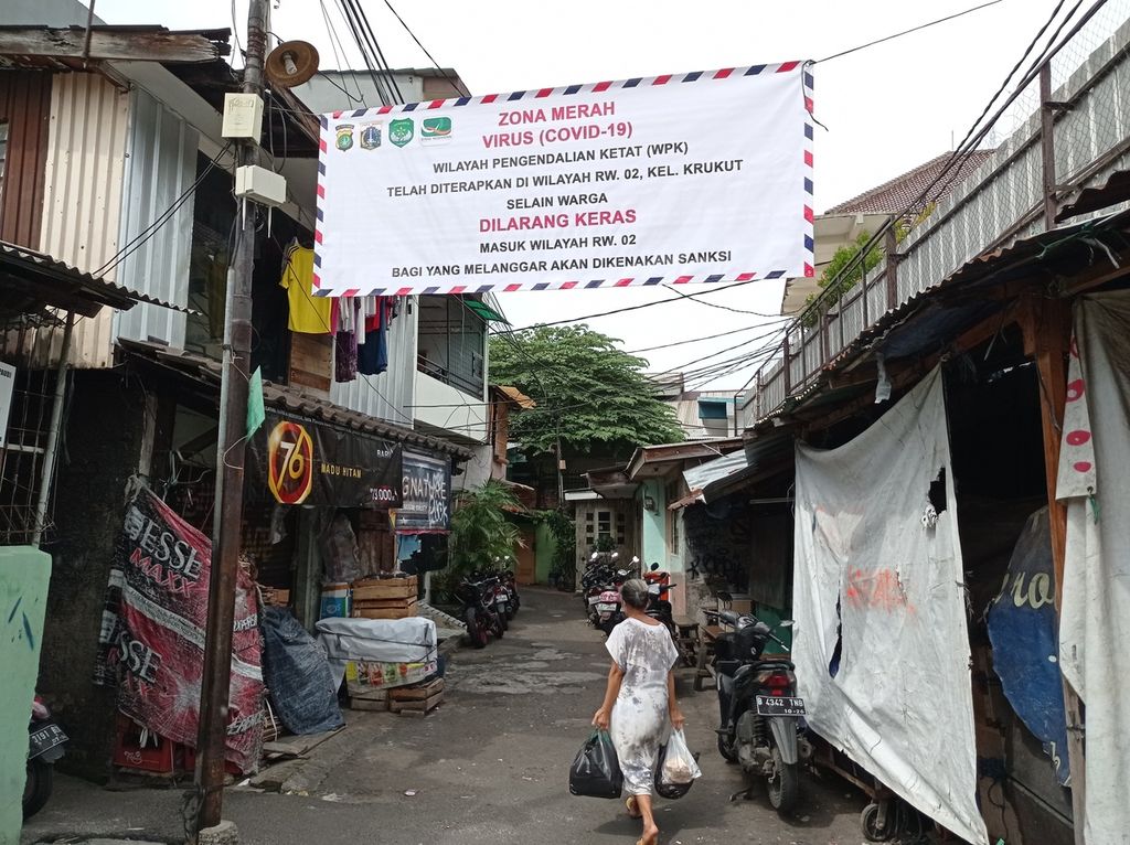 Spanduk yang menyatakan wilayah RW 002, Kelurahan Krukut, Jakarta Barat, menjalani penguncian lokal atau <i>micro-lockdown</i> akibat merebaknya Covid-19, Senin (10/1/2022).