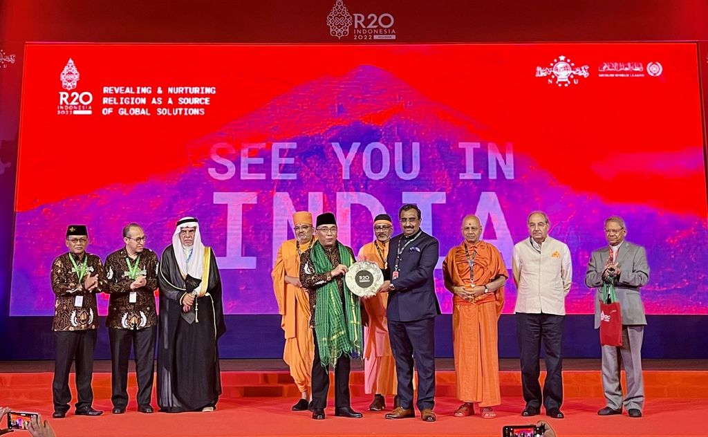 Ketua Umum Pengurus Besar Nahdlatul Ulama KH Yahya Cholil Staquf menyerahkan plakat G20 Religion Forum atau R20 kepada tokoh agama dari India, HH Mahamahopadhyaya, saat penutupan forum R20 di Nusa Dua, Bali, Kamis (3/11/2022). India akan menjadi tuan rumah R20 pada 2023 mendatang.