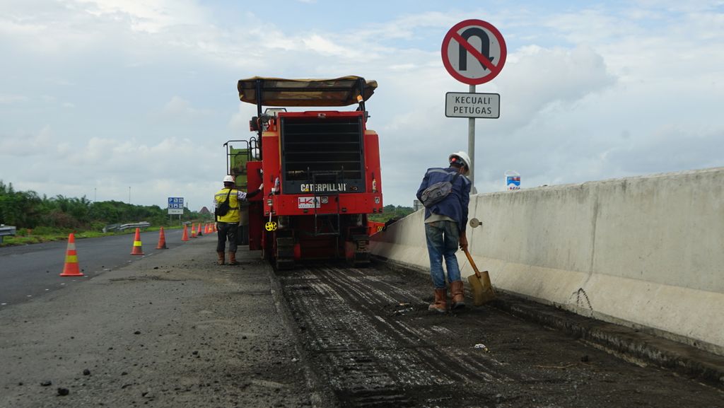 Sejumlah pekerja memperbaiki jalan di ruas tol Kayu Agung-Pematang Panggang-Terbanggi Besar Km 310, Kamis (9/12/2021). Perbaikan jalan ini dilakukan jelang Natal dan Tahun Baru yang diprediksi akan membuat volume kendaraan yang melintas meningkat.