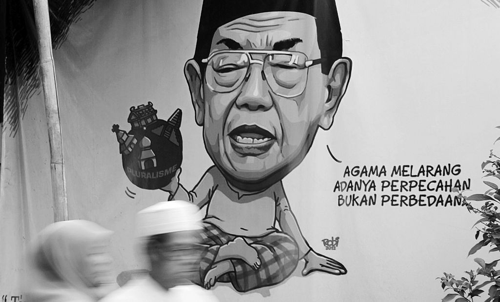 Warga melintas di depan spanduk yang mengutip pernyataan mantan Presiden RI KH Abdurrahman Wahid (Gus Dur) di kawasan Duren Sawit, Jakarta Timur, Minggu (10/8/2014). Gus Dur dikenal sebagai tokoh bangsa yang memberi tempat lebih layak bagi kaum minoritas di Indonesia.