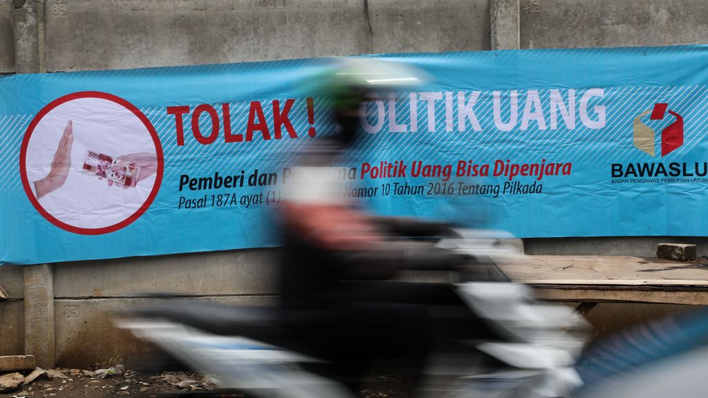 Spanduk ajakan untuk menolak paraktik politik uang dalam Pilkada 2020 terpasang di Jalan Jombang Astek, Serpong, Tangerang Selatan, Senin (7/12/2020). 