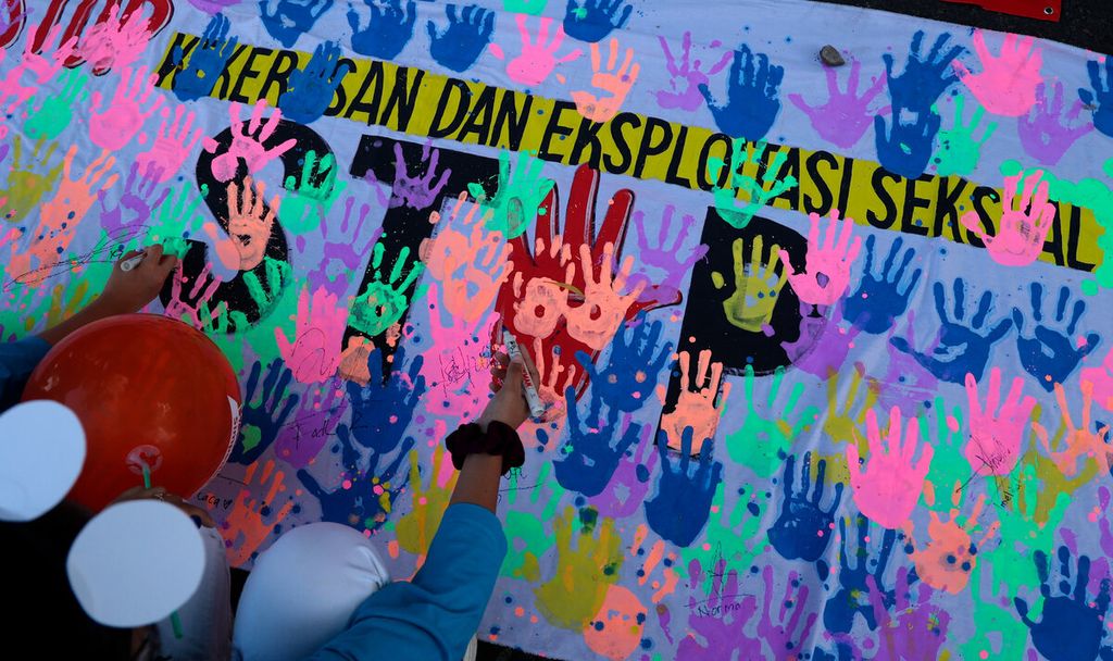 Peserta aksi menuliskan pesan dukungan terhadap kampanye antikekerasan dan eksploitasi seksual pada anak di Jalan Slamet Riyadi, Kota Surakarta, Jawa Tengah, Juli 2022. 