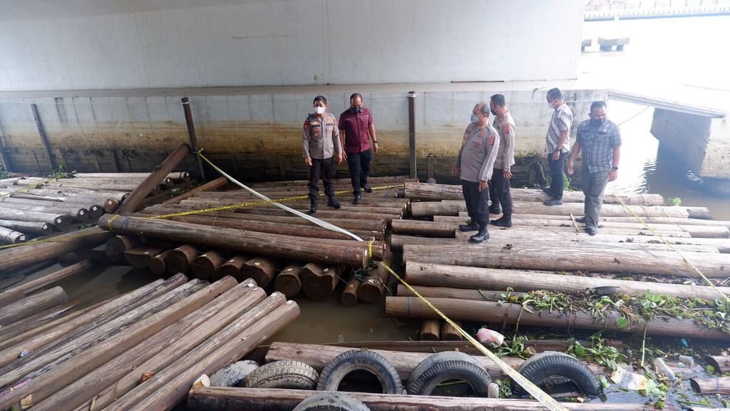 Polisi mengecek tumpukan kayu bulat yang disita di Sungai Martapura, Kota Banjarmasin, Kalimantan Selatan, pertengahan Maret 2022. 