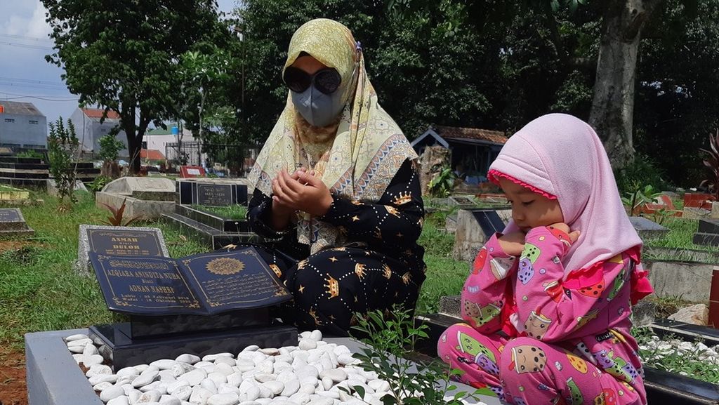 Soliha, resident of Depok, West Java, accompanied by her niece Nai (3 years old) visited the grave of her daughter Azqira, Tuesday (25/10/2022).  Azqira Anindita Nuha died over a week before due to infection of acute kidney injury. 
