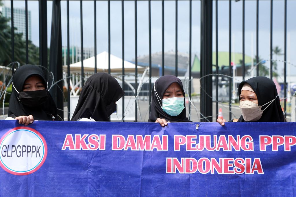 Guru membawa spanduk aksi di depan gedung DPR RI, Jakarta, Kamis (24/11/2022). Guru-guru lulus  <i>passing grade</i> dari sekolah negeri dan swasta yang datang dari sejumlah daerah itu berunjuk rasa di depan kantor DPR RI. 