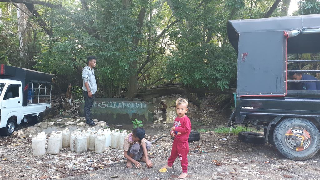 Anak-anak ikut antre mengambil air bersih di kali dekat Pos Lintas Batas Motamasin, Kabupaten Malaka, Provinsi Nusa Tenggara Timur, Senin (10/1/2022). Krisis air bersih menjadi masalah di kawasan perbatasan negara Timor Leste itu.