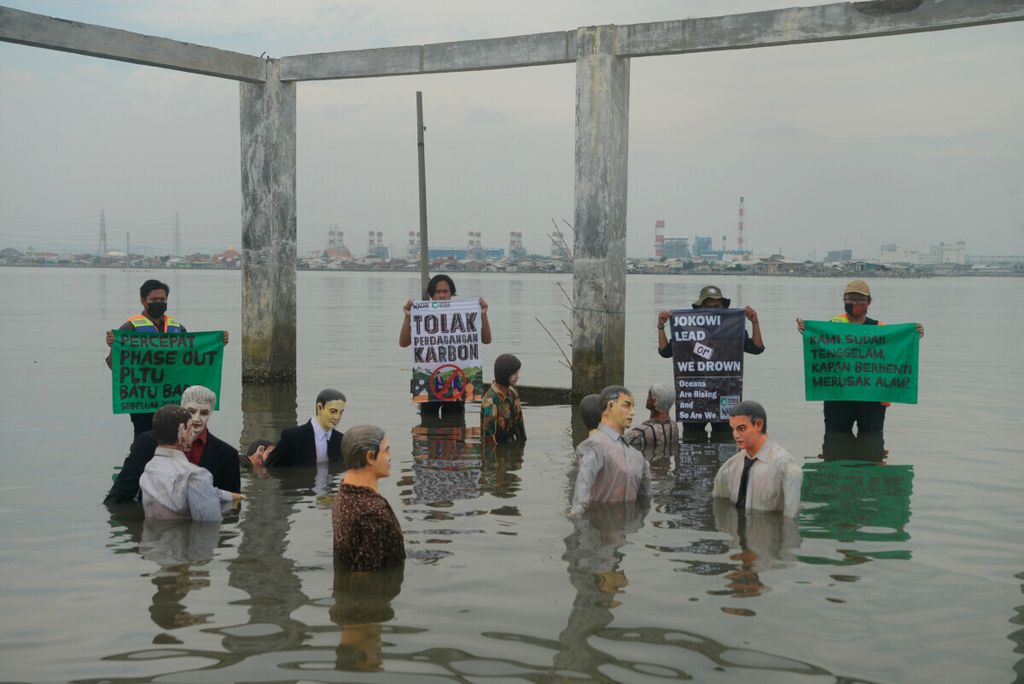 Aktivis Wahana Lingkungan Hidup Indonesia (Walhi) Jawa Tengah beserta komunitas membentangkan poster berisi kritikan kepada pemerintah tentang persoalan lingkungan di Tambakrejo, Kota Semarang, Jawa Tengah, Jumat (5/11/2021). 