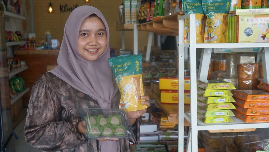 Lona Sari, pemilik toko oleh-oleh di Bangkinang, Kabupaten Kampar, Riau, menunjukan sejumlah produk yang dijualnya, Jumat (6/1/2023). Bagi pemilik toko, keberadaan jalan tol diharapkan tidak membuat pendapatannya surut. 