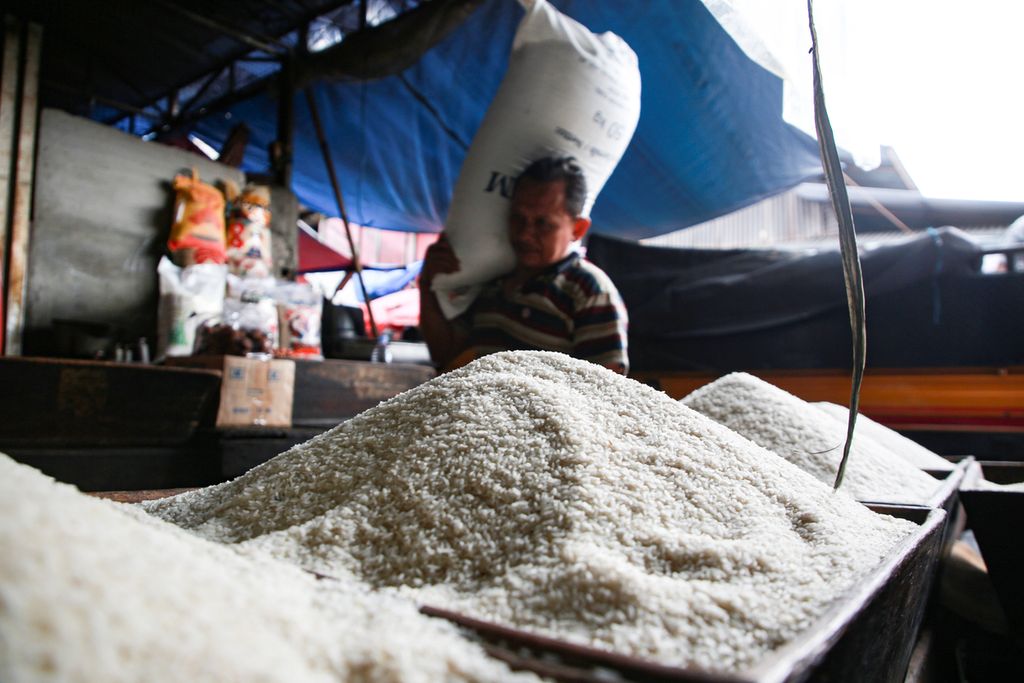 Pekerja memanggul karung berisi beras ke dalam gudang di toko beras Matahari di Pasar Kebayoran Lama, Jakarta Selatan, Senin (2/1/2023). Beras menjadi salah satu komoditas penyumbang inflasi Desember 2022 sebesar 0,66 persen.