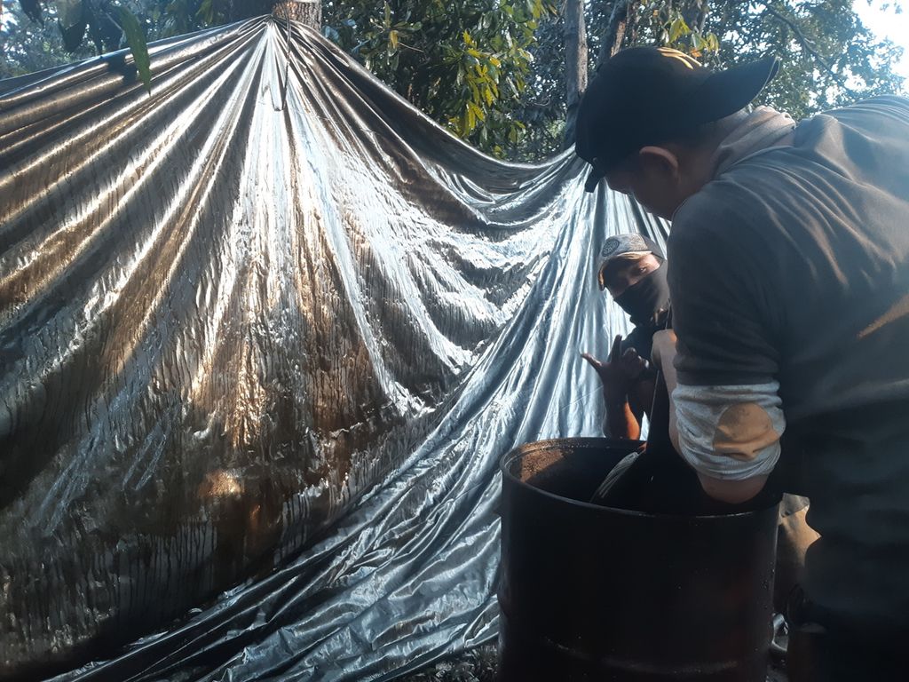 Suasana di area tambang minyak ilegal di Kelurahan Keluang, Kecamatan Keluang, Kabupaten Musi Banyuasin, Sumatera Selatan, Jumat (16/9/2022). Semburan minyak yang berlangsung sejak Rabu (14/9/2022) membuat area itu dipenuhi minyak mentah. Warga pun berbondong-bondong mengais minyak.