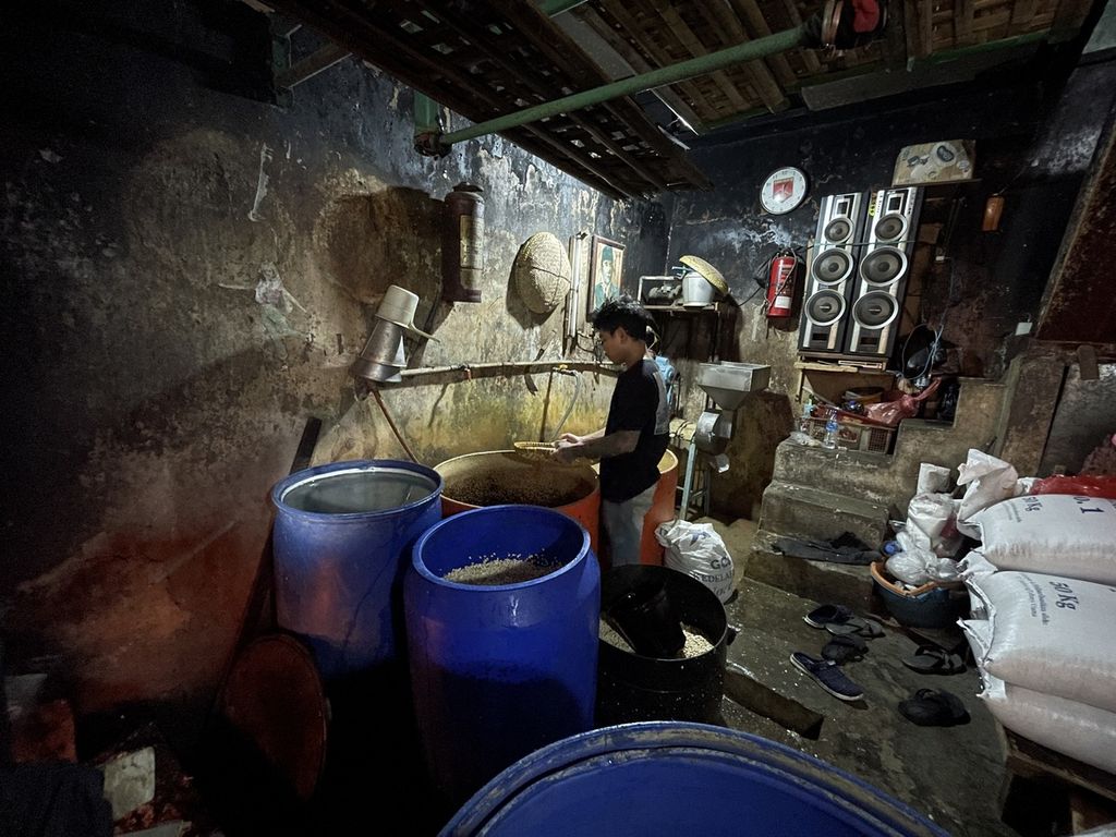 Rafi, perajin tempe, menaburkan ragi yang akan dicampur dengan kedelai dalam proses pembuatan tempe di Johar Baru, Jakarta Pusat, Jumat (14/10/2022). Perajin tempe mengeluhkan harga kedelai yang terus melonjak.