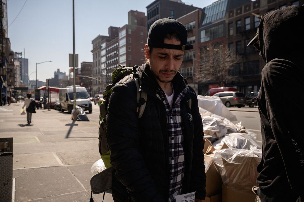 Arnie Medero berdiri di luar Bowery Mission, sebuah organisasi nirlaba yang merawat warga New York yang menjadi tunawisma, mengalami kelaparan, dan krisis lainnya, setelah menerima makan siang gratis di kampusnya di New York, AS, Rabu (16/3/2022). AFP/Ed JONES 16-03-2022 