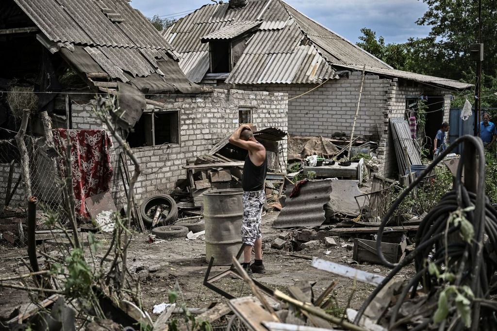 Maksym Katerin, warga, berdiri di antara puing-puing rumahnya yang hancur, sementara ibu dan ayah tirinya tewas di tengah pertempuran di kota Lysychansk, wilayah Donbas, Ukraina timur, 13 Juni 2022. 