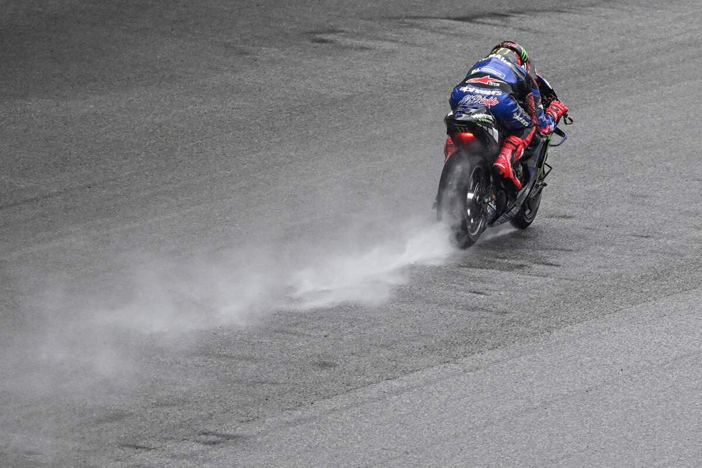 Pebalap Monster Energy Yamaha, Fabio Quartararo, beraksi di tengah hujan saat tes pramusim MotoGP musim 2023 hari kedua di Sirkuit Sepang, Malaysia, Sabtu (11/2/2023). 