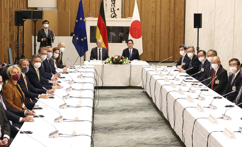 Kanselir Jerman Oraf Scholz (tengah, kiri) dan PM Jepang Fumio Kishida (tengah) berfoto bersama dengan para tokoh bisnis Jerman dan Jepang seusai pertemuan puncak kedua pemimpin di kediaman PM di Tokyo, Jepang, Kamis (28/4/2022). 
