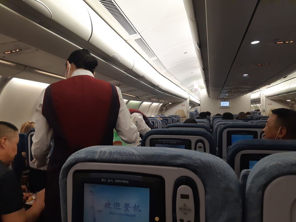 Pramugari menyajikan makan malam bagi penumpang dalam penerbangan Jakarta-Beijing, Senin (27/2/2023). Setelah pemerintah China menghapus kebijakan nihil Covid-19 atau Zero Covid Policy, syarat bepergian ekstra ketat yang sebelumnya berlaku bagi pendatang dicabut.
