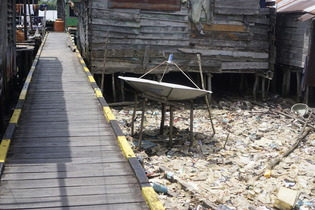 Sampah plastik berceceran di sekitar rumah panggung warga di Desa Muara Adang, Kecamatan Long Ikis, Kabupaten Paser, Kalimantan Timur, Kamis (15/2/2023).