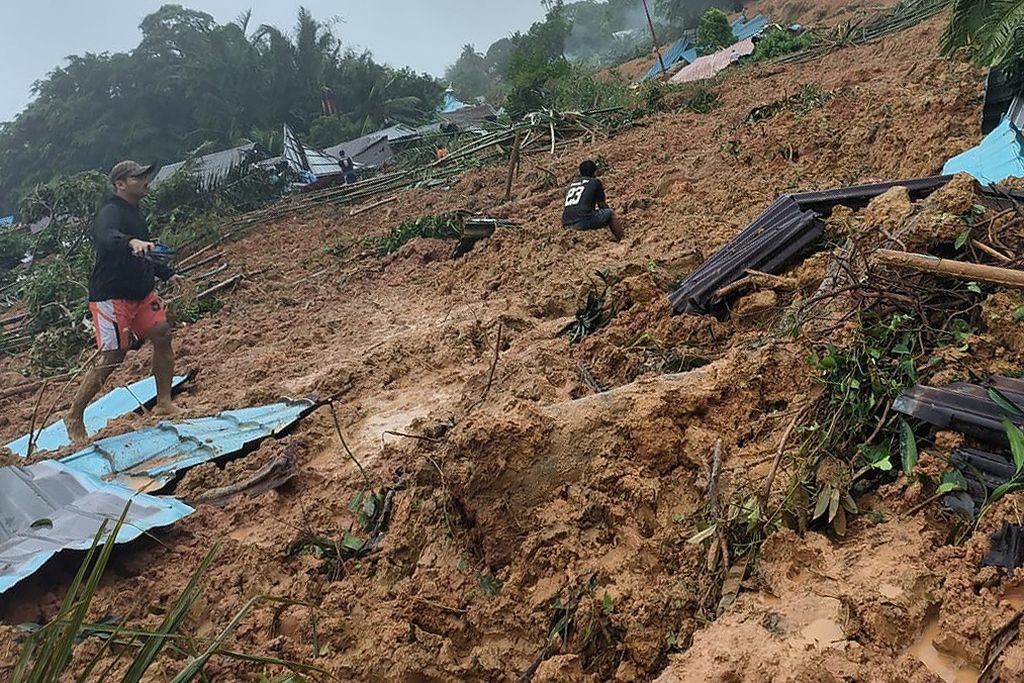 A man walks at the site of a landslide disaster in Serasan District, Natuna Regency, Riau Islands, Monday (6/3/2023).