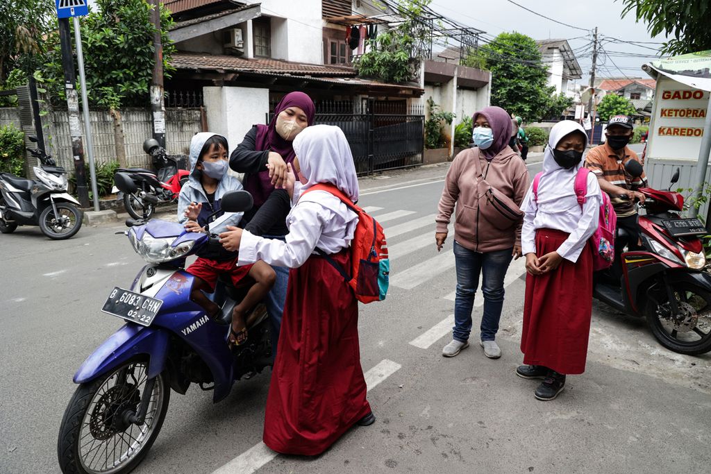 Orangtua mengantar anaknya hingga ke gerbang sekolah di SD Negeri Joglo 05, Kembangan, Jakarta Barat, Selasa (31/1/2023). Tidak hanya mengantar dan menjemput, orangtua dan sekolah juga berupaya memberi pengertian kepada anak untuk tidak menerima pemberian dan bujuk rayu dari orang asing. 