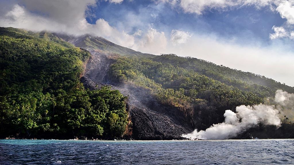 Guguran material vulkanik Gunung Karangetang yang jatuh ke laut diamati dari sisi barat Pulau Siau, Kabupaten Kepulauan Sitaro, Sulut, 10 Februari 2019.