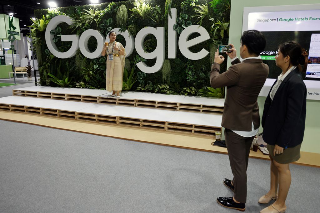 Orang mengabadikan rekannya dengan kamera telepon seluler, berlatar tulisan besar Google, di ajang APEC, di Bangkok, Thailand, 18 November 2022. 