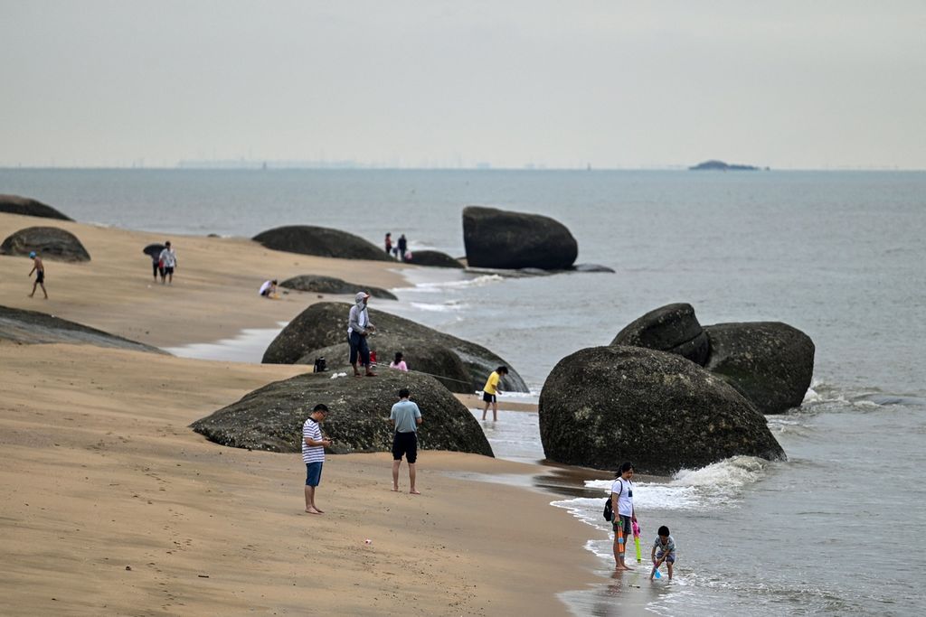 Warga berkumpul di pantai di Kota Xiamen, Selasa (3/8/2022), wilayah terdekat China yang berbatasan dengan Taiwan. Tampak di latar belakang adalah Pulau Kinmen, Taiwan. 