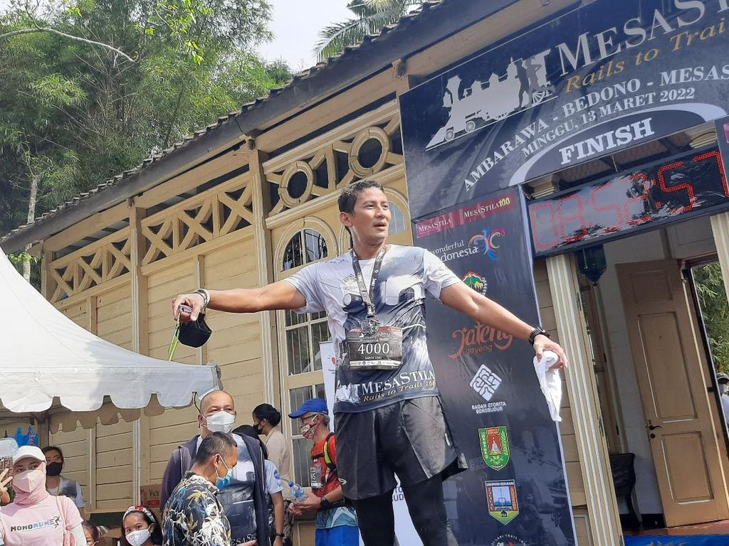 Menteri Pariwisata dan Ekonomi Kreatif Sandiaga S Uno berdiri di atas podium, melepaskan kegembiraannya setelah menuntaskan berlari hingga di garis finish, dalam ajang MesaStila Rails To Trails di Magelang, Jawa Tengah (14/3/2022)