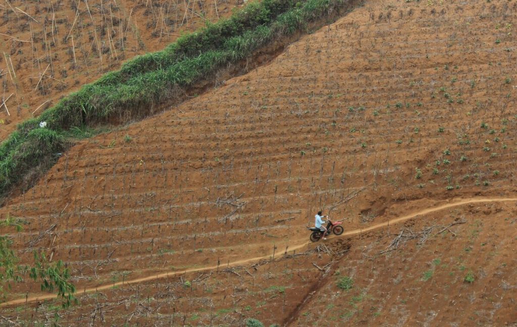 Pengendara sepeda motor melintasi perbukitan yang dimanfaatkan menjadi kebun sayur di Desa Mekarsaluyu, Kecamatan Cimenyan, Kabupaten Bandung, Jawa Barat, Senin (25/11/2019).