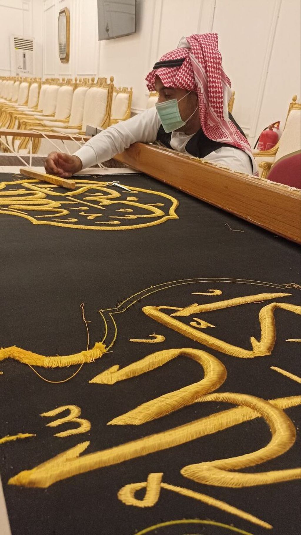 Seorang seniman sedang menyulam kaligrafi Arab dengan benang emas di atas kain penutup (kiswah) berwarna hitam di Majma al-Malik Abdul Aziz li Kiswah al-Kabah di Mekkah, Arab Saudi, Rabu (27/7/2022). Kiswah ini nanti dipasang untuk menutupi Kabah di Masjidil Haram.