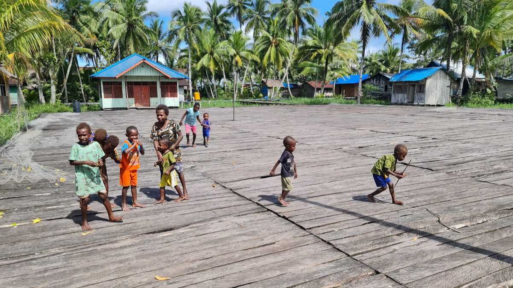 Sejumlah anak-anak di Kampung Birak, Distrik Jetsy, Kabupaten Asmat, Papua, bermain di lapangan olahraga, Rabu (22/7/2022) siang. Lapangan yang terbuat dari papan yang berdiri di atas permukaan rawa-rawa, merupakan bantuan pembaca harian <i>Kompas</i> melalui Yayasan Dana Kemanusiaan Kompas.