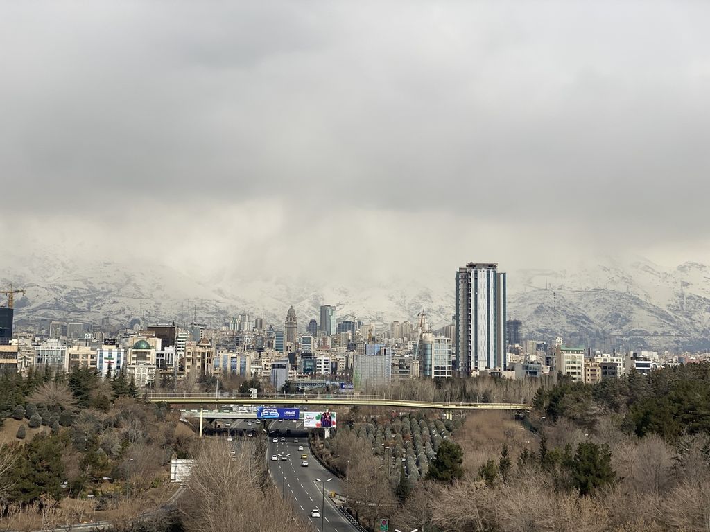 Kota Teheran, ibu kota Iran, dilihat dari Jembatan Tabiat, Sabtu (11/02/2023), dengan pemandangan pegunungan bersalju di kejauhan.