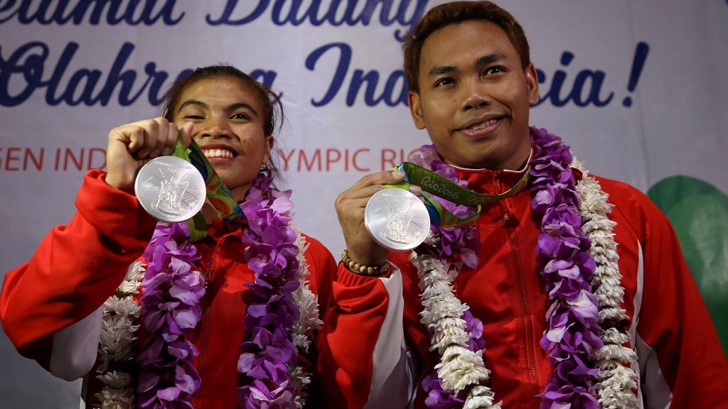 Lifter angkat besi Indonesia Eko Yuli Irawan (kanan) dan Sri Wahyuni menunjukkan medali perak yang mereka raih di Olimpiade Rio de Janeiro 2016 setibanya di Bandara Internasional Soekarno-Hatta, Tangerang, Banten, Minggu (14/8).