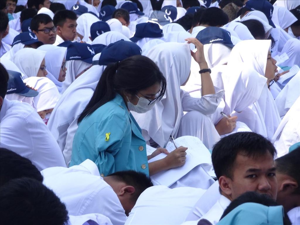 Mahasiswa baru Universitas Sebelas Maret (UNS) membuat catatan saat mengikuti kuliah umum Menteri Pertahanan Ryamizard Ryacudu di halaman Rektorat UNS di Solo, Jawa Tengah, Selasa (13/8/2019).