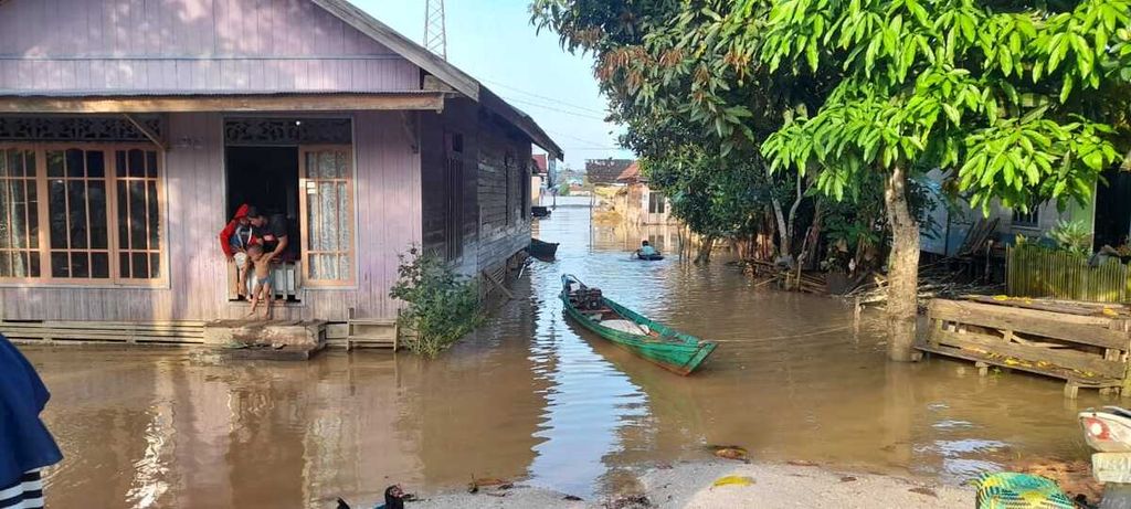 Warga Tumbang Samba, Kabupaten Katingan, Kalteng, harus menggunakan perahu untuk mobilitas di sekitar rumah karena banjir yang melanda wilayah tersebut, Minggu (7/8/2022).