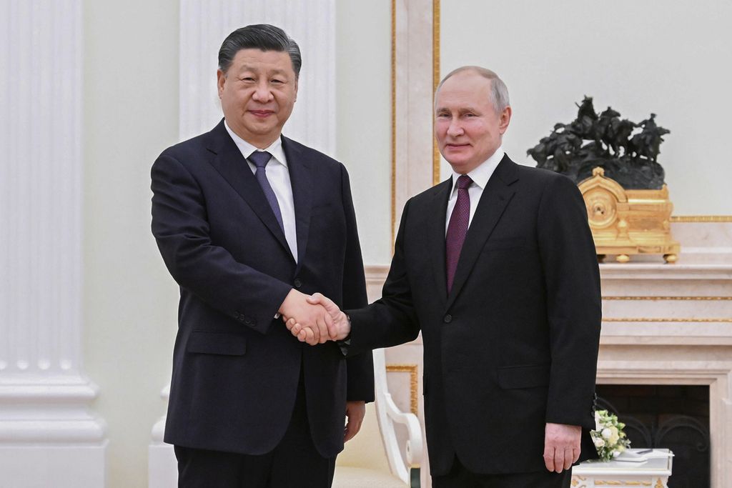 Presiden China Xi Jinping (kiri) berjabat tangan dengan Presiden Rusia Vladimir Putin dalam pertemuan di Kremlin, Moskwa, Rusia, Senin (20/3/2023). 